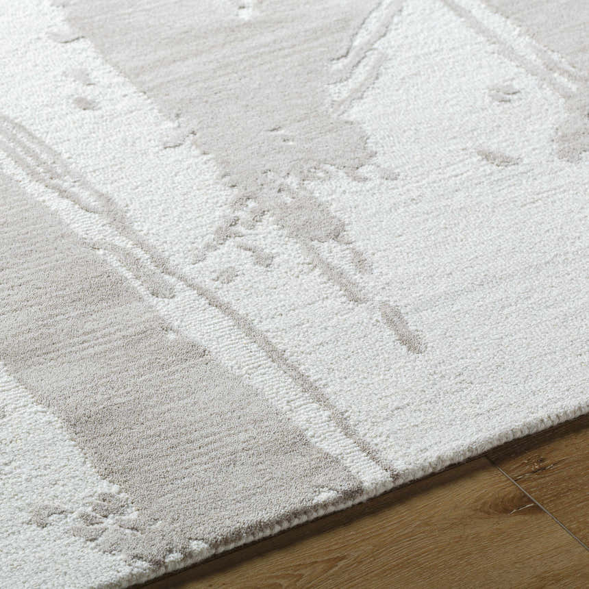 Close-up of the Viven Ivory Area Rug. Hand-tufted wool rug with a subtle silver gray abstract pattern. Soft texture. Texture
