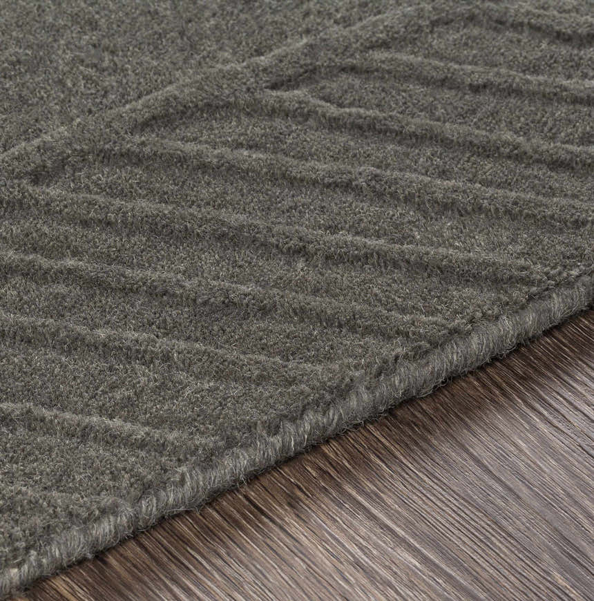 Close-up of the charcoal Everson Carpet Area Rug, a hand-loomed wool rug with a subtle geometric pattern. Texture