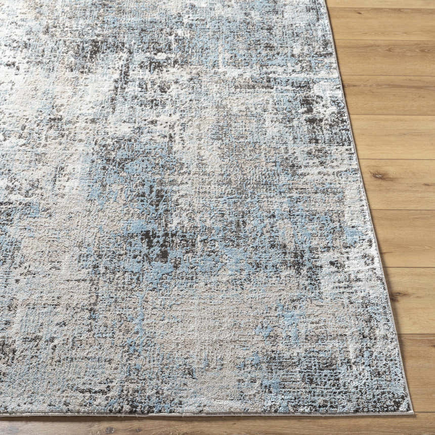 Close-up of the Vesna Blue Area Rug showing its abstract Southwestern design and blue, charcoal, and ivory colors. Front