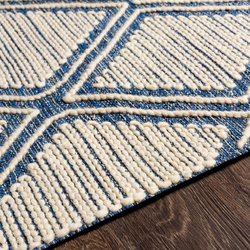 Close-up of the hand woven Walgett Carpet Area Rug. Blue cotton rug with cream geometric pattern and textured detail. Texture