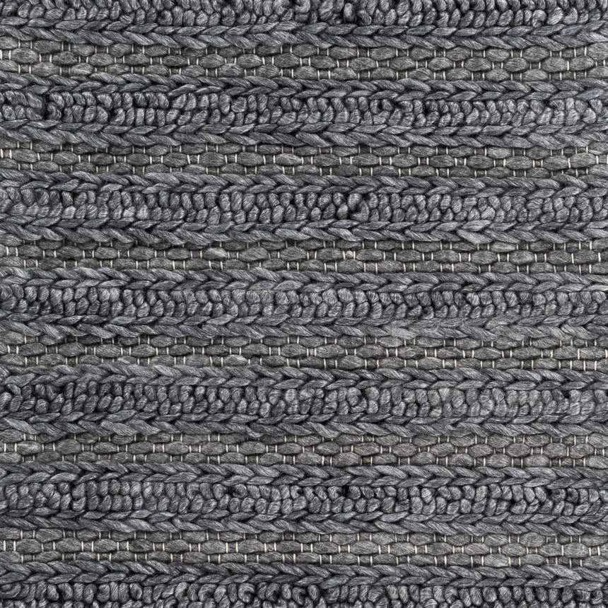 Close-up of the hand woven Warrendale Area Rug. Charcoal gray, natural fibers, contemporary style. Braided texture detail. Swatch