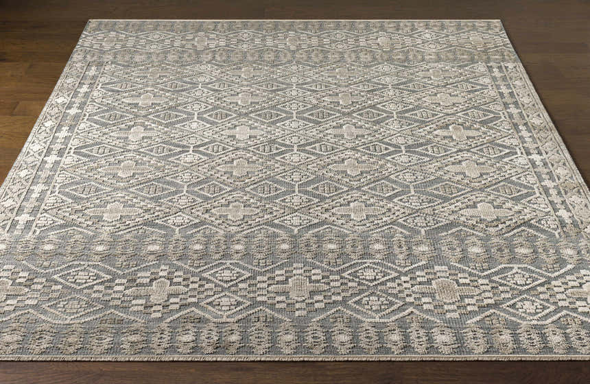 Close-up of the hand-knotted Woodsfield Premium Rug. Beige, brown, and gray geometric pattern. Wool texture. Front