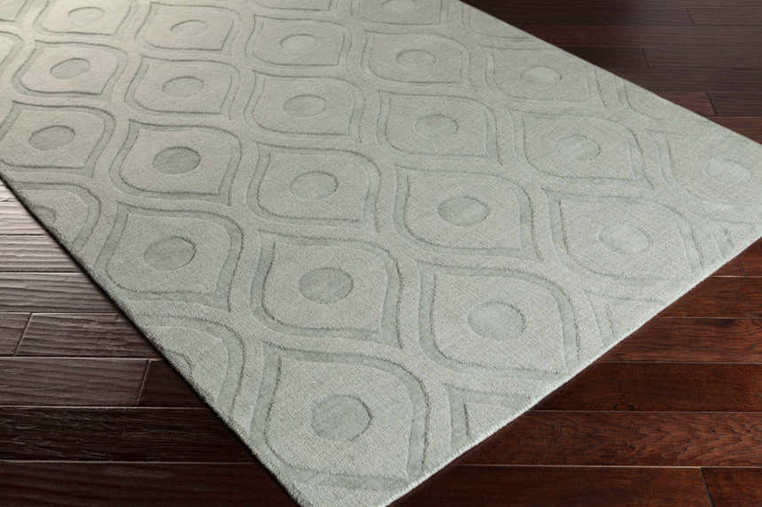 Close-up of the light gray Welaka Eye Pattern Wool Rug on dark hardwood floor, showing the textured geometric design. Corner