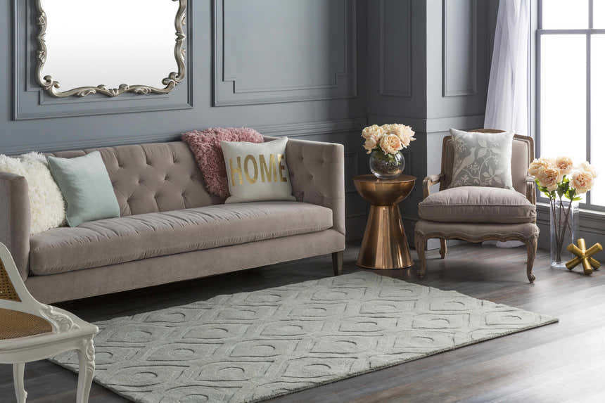 Gray living room with a Welaka Eye Pattern Wool Rug, tufted sofa, and gold accents. Roomscene-Rectangle