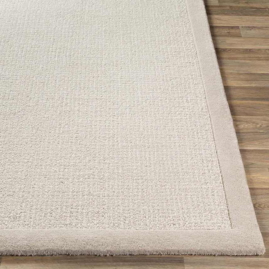 Close-up of the hand-tufted Winooski Area Rug. Cream and light gray wool rug with a solid striped design and soft texture. Front