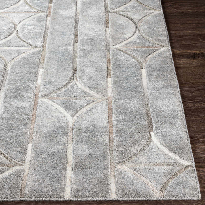 Close-up of the Willingham Area Rug. Charcoal, light beige, and gray geometric pattern on a hand-crafted viscose rug. Front