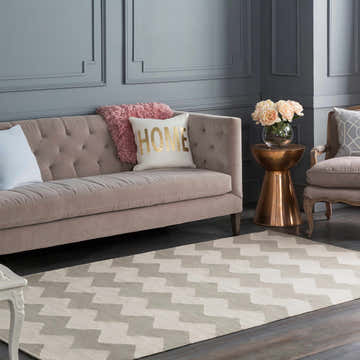 Living room scene with a Walters Gray Zig Zag Cotton Rug, beige sofa, and gray walls. Roomscene-Runner