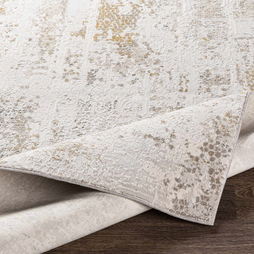 Close-up of the Windale Textured Luxe Area Rug. Features off-white, gray, and mustard tones with a subtle, contemporary pattern. Fold