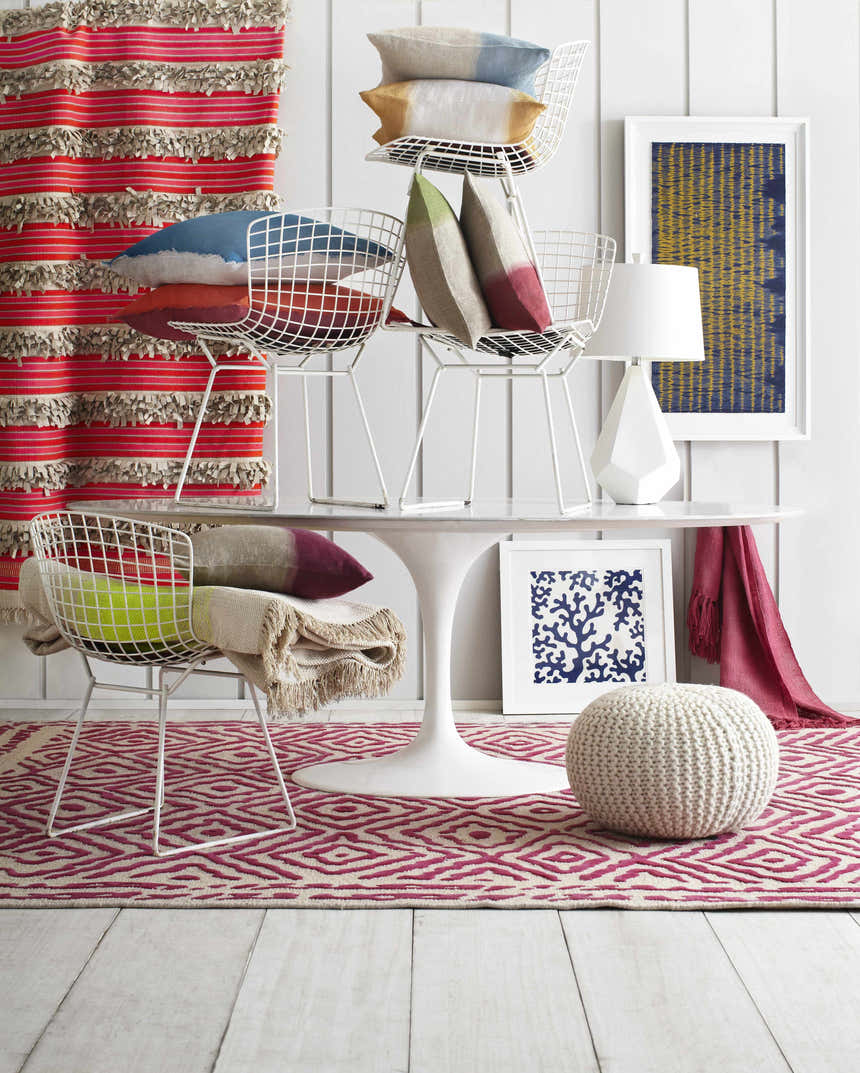 Styled room featuring the Westhill Area Carpet. Fuchsia and beige rug with geometric pattern, white furniture, and colorful accents. Styleshot