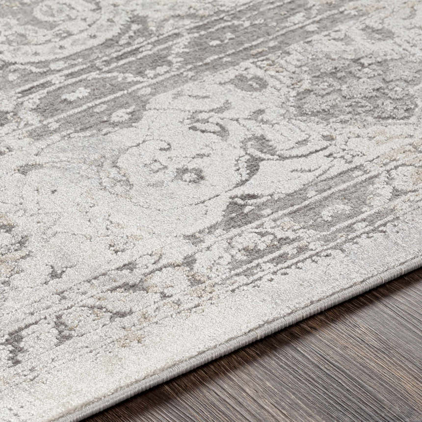 Close-up of the Withams Textured Luxe Area Rug, showing its charcoal, cream, and gray traditional pattern and textured weave. Texture