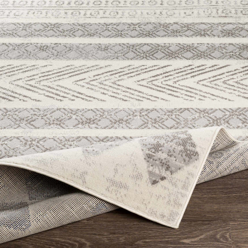 Close-up of the Wyoming Area Rug, showcasing its gray and off-white bohemian-inspired pattern and machine-woven texture. Fold
