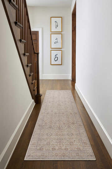 Hallway scene with a vintage Xipil Area Rug runner, wood floors, staircase, and framed art. Neutral color palette. Roomscene-Runner