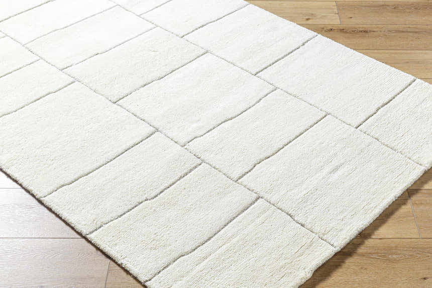 Close up of a light silver Xylia Charcoal Area Rug with a contemporary block design and a soft, wool texture. Corner