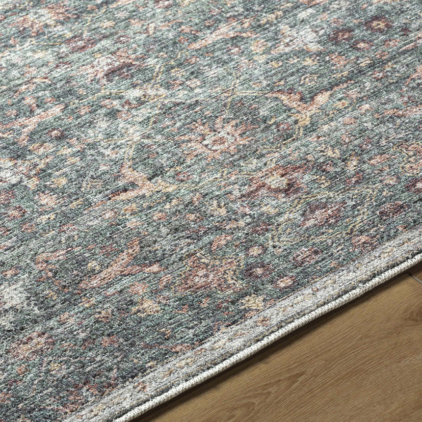 Close-up of the Zilya Area Rug, a machine-woven rug with dark brown, green, peach, rust, and white traditional pattern. Texture