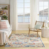 Coastal living room with a Nourison Aloha Grey Multicolor Farmhouse Area Rug, white sofa, and ocean view.