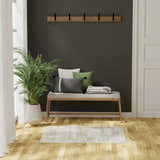 Entryway scene with a Nourison Dekor Ivory Beige rug, bench with pillows, dark walls, and wood floors.
