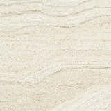 Close-up of the ivory Nourison Graceful Rug. The wool rug has a subtle wave pattern and a soft, textured pile.