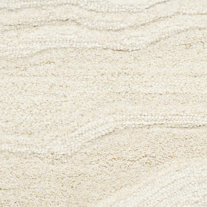 Close-up of the ivory Nourison Graceful Rug. The wool rug has a subtle wave pattern and a soft, textured pile.