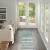 Hallway scene with a Nourison Positano Aqua Ivory rug, light wood floors, neutral sofa, and outdoor patio view.