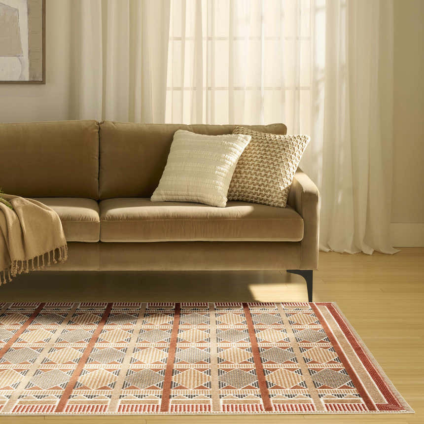 Living room scene with a Nourison Nordic Rust Multicolor rug, tan sofa, and neutral decor.