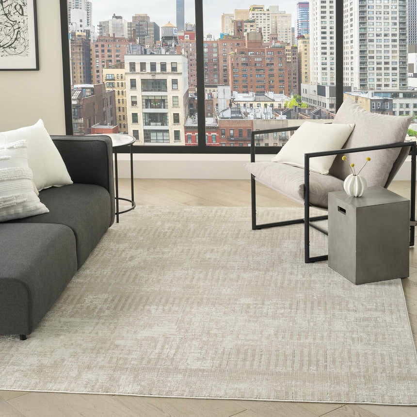 Modern living room with DKNY Grand Street Ivory Beige rug, gray sofa, chair, and city view.