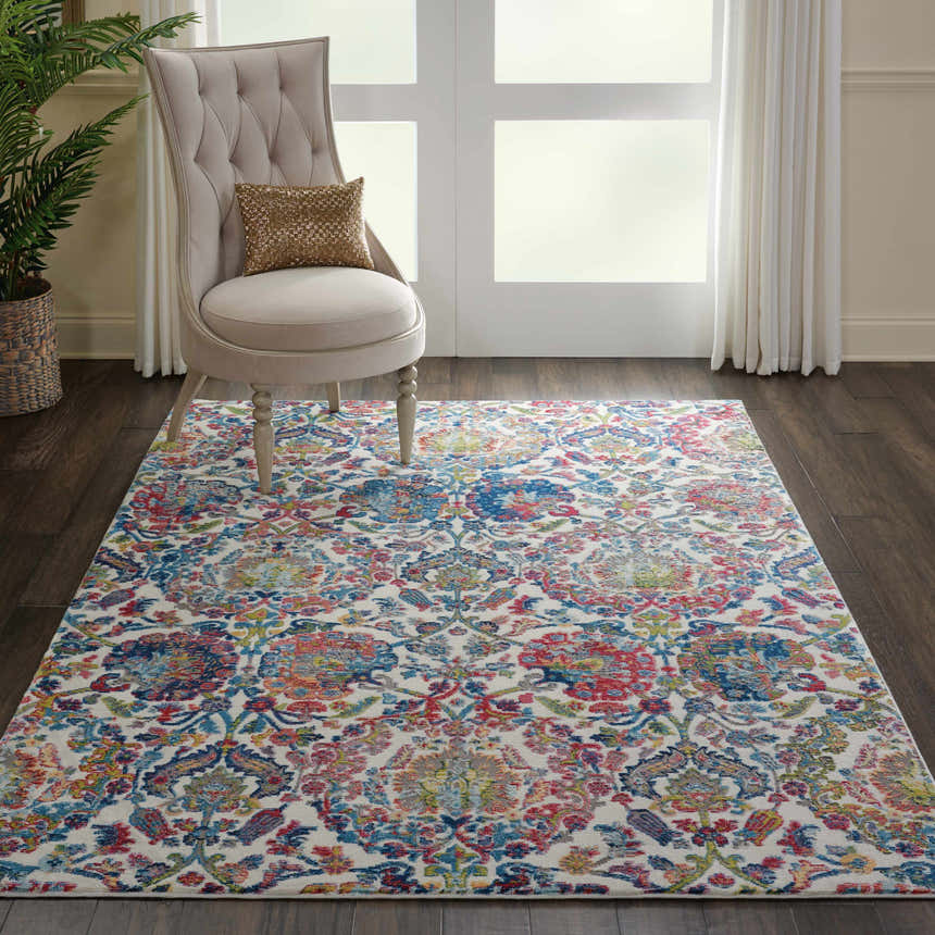 Living room scene with Nourison Ankara Global Ivory Blue Vintage rug, beige chair, and dark wood floors.
