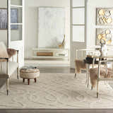 Living room scene with cream furniture and a Nourison Cozumel Cream Farmhouse Area Rug, featuring a geometric design.