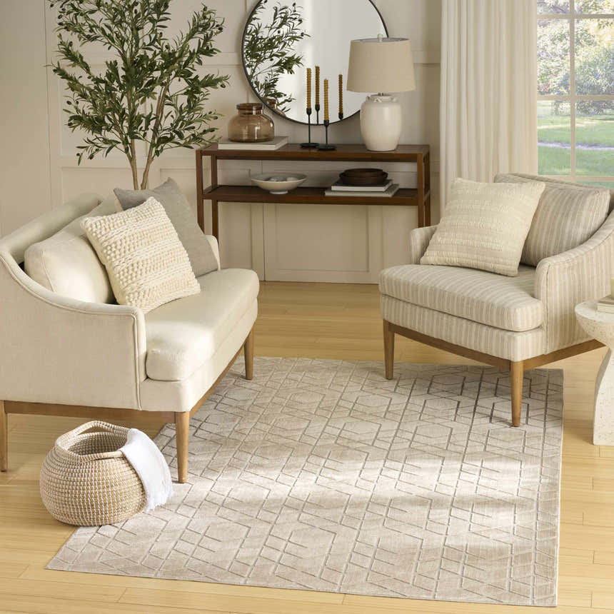 Living room scene with a Nourison Charm Beige Ivory rug, sofa, chair, and console table.