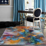Modern office with Nourison Le Reve Multicolor rug, dark desk, silver chair, and blue curtains.