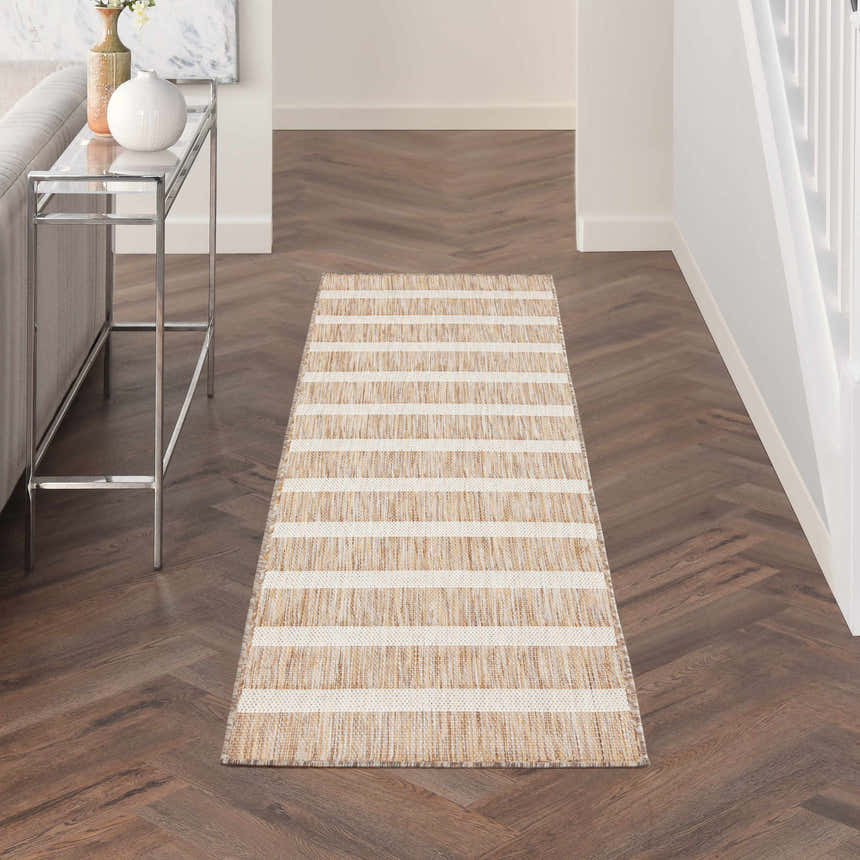 Hallway scene with a Nourison Positano beige ivory rug runner on dark wood floors. Modern console table.