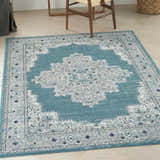 Light wood floor with Nourison Passion Turquoise Grey rug, chair legs visible.