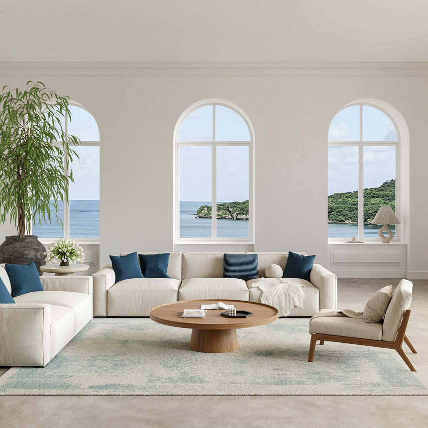 Coastal living room with ivory sofas and Nourison Harmony Ivory Aqua rug, ocean view.
