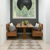 Breakfast nook with Nourison Modern Jute Natural Ivory rug, wood table, built-in benches, gray accent wall, and modern pendant light.