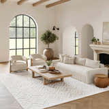 Living room with a Nourison Versatile Ivory White rug, beige sofa, chairs, wood accents, and a modern, neutral aesthetic.