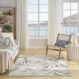Coastal living room with Nourison Aloha Ivory Sage rug, sofa, chair, and ocean view.