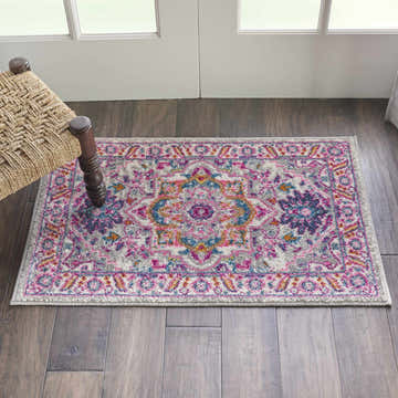 Entryway with Nourison Passion Light Grey Pink Bohemian Indoor Area Rug, wood floors, and woven chair.