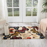 Light-filled room featuring Nourison Fantasy Beige Floral Indoor Area Rug with colorful butterfly design on wood floor.