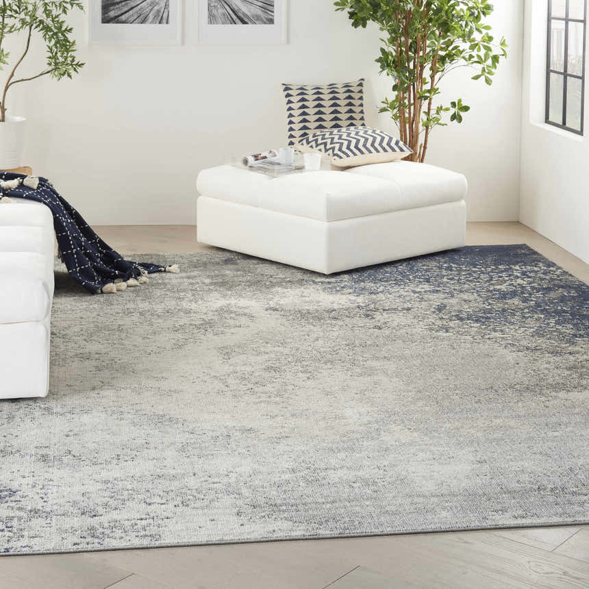 Modern living room with a Nourison Passion Charcoal Ivory rug, white sofa and ottoman.