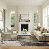 Living room scene with a Nourison Celestial Ivory Grey rug, fireplace, sofa, and chairs.