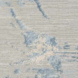 Close-up of Calvin Klein CK005 Enchanting Grey Sky rug. High pile, contemporary style with blue and cream abstract pattern.