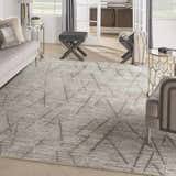 Living room scene with the Nourison OCEAN Stone rug, gray sofa, and modern gold accent tables.