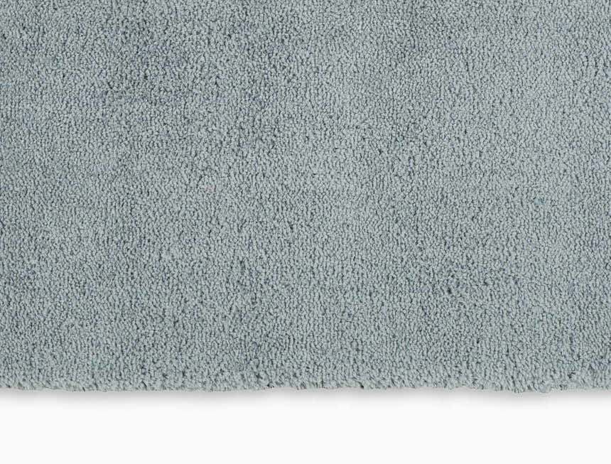 Close-up of the Calvin Klein Chicago Shag rug. Soft, dense pile in light grey. Modern, plush texture.