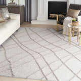 Living room scene with a Nourison Feather Soft Grey rug, white sofa, and black fireplace.
