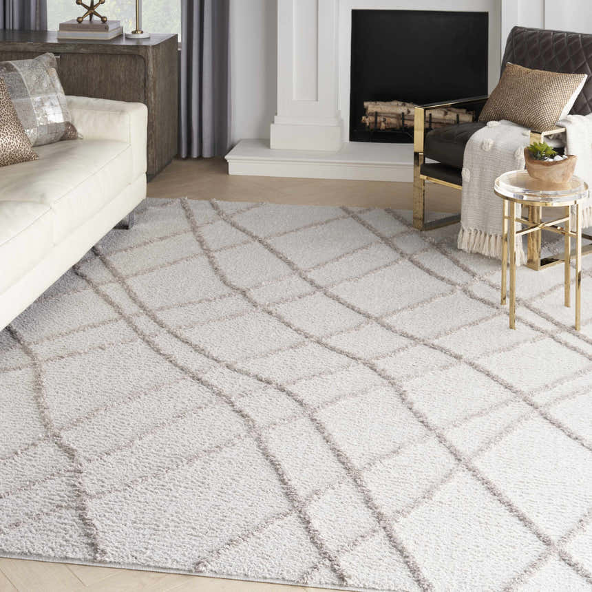 Living room scene with a Nourison Feather Soft Grey rug, white sofa, and black fireplace.