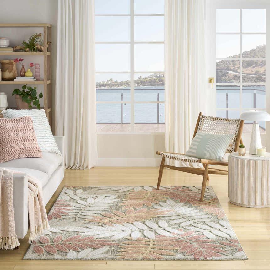 Coastal living room with white sofa and Nourison Aloha Sage Rose Modern Area Rug featuring a leaf pattern.