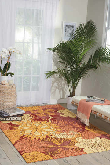 Living room scene with floral Nourison South Beach Spice Area Rug in spice tones, white furniture, and natural light.