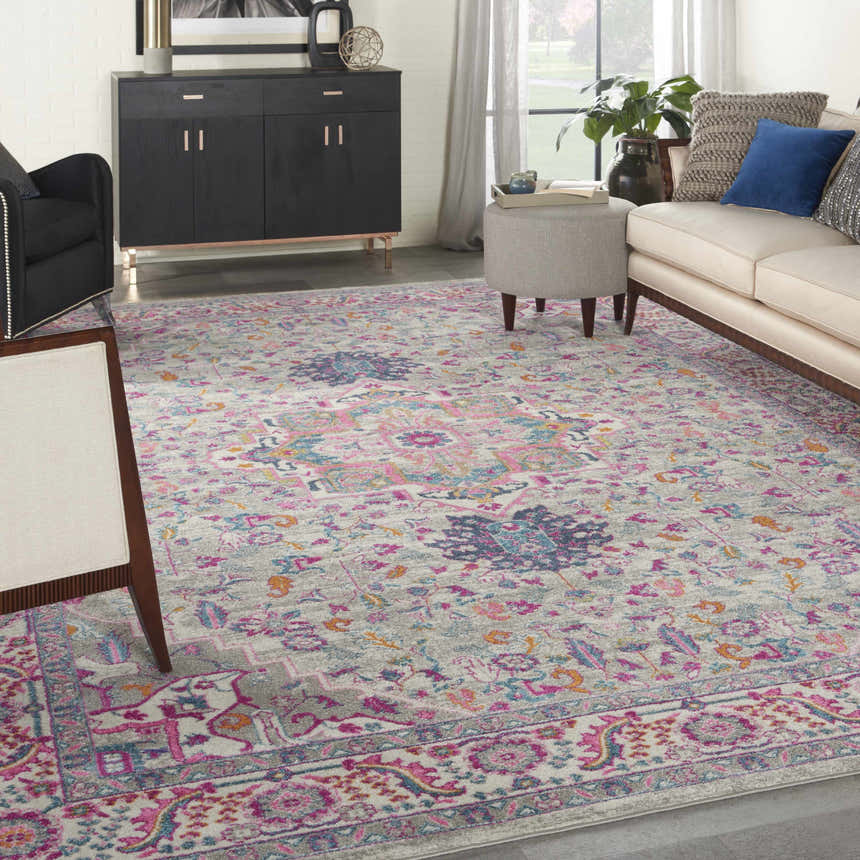 Living room scene with a Nourison Passion Light Grey Pink Bohemian Indoor Area Rug, sofa, and black cabinet.
