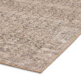 Close-up of the Four Hands Priya Area Rug featuring a traditional design in camel, light beige, and tan hues. Corner