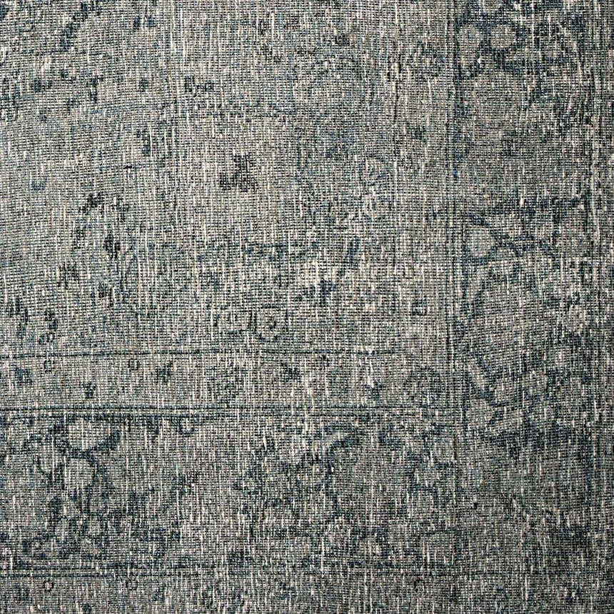 Close-up of the Four Hands Morelli Blue Area Rug, showing its woven texture and traditional vintage pattern. Texture