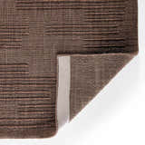 Close up of the taupe Four Hands Geist Rug showing its striped pattern and hand-loomed texture. Fold